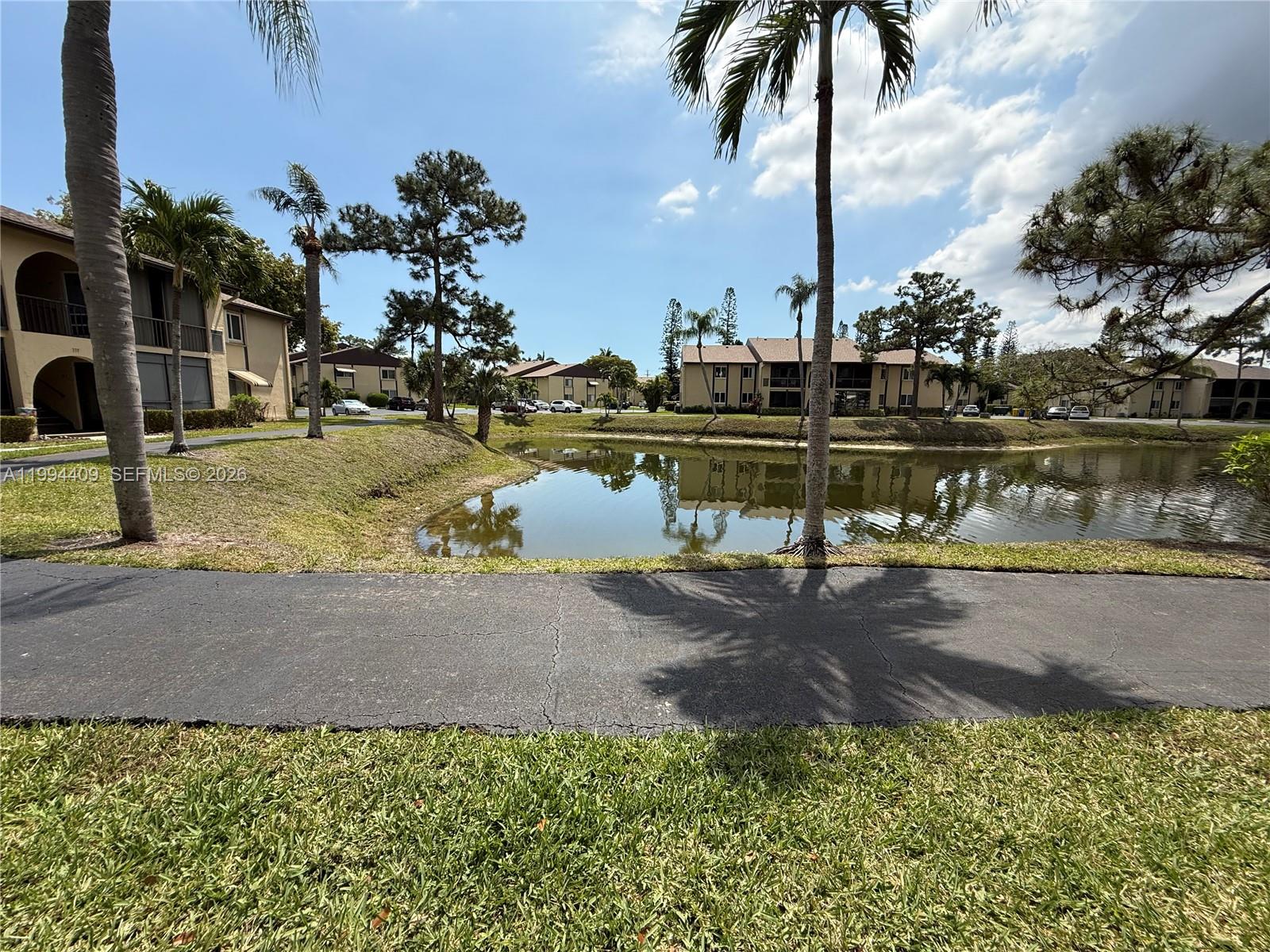 340 Pine Ridge Circle, Unit C1 Greenacres, FL 33463 - Photo 6 of 24 a view of a lake with a house