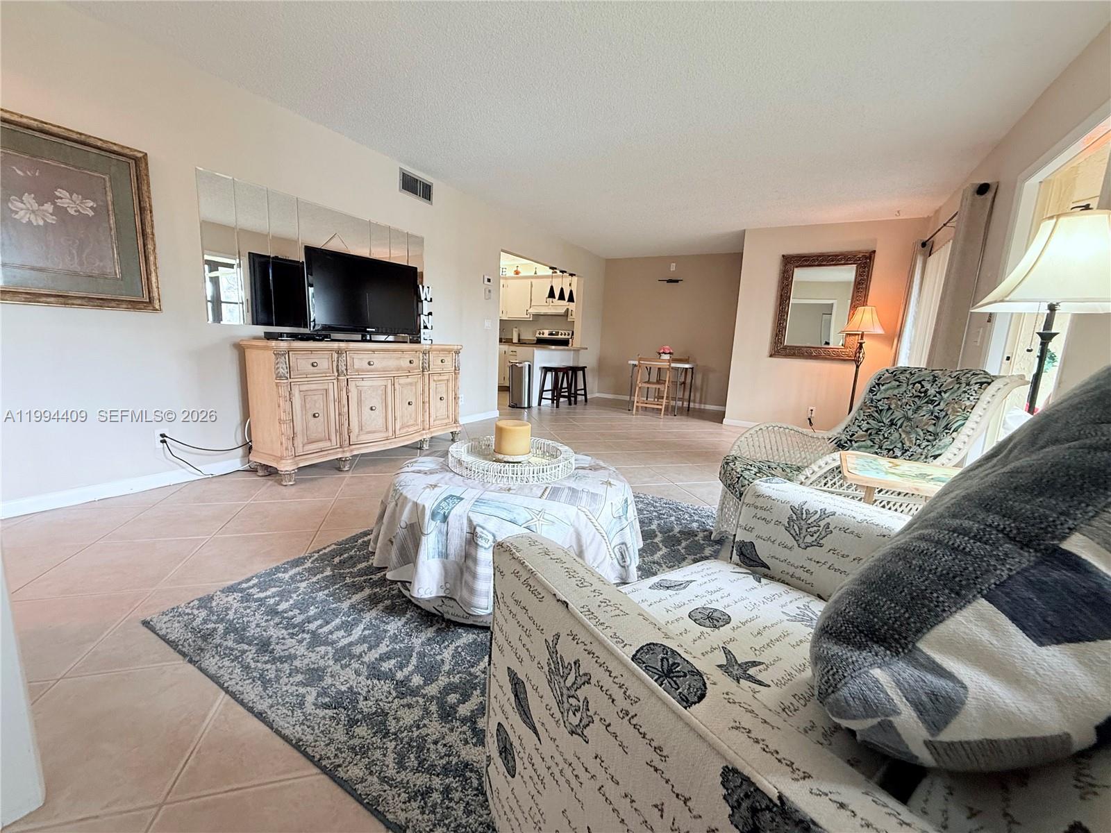 340 Pine Ridge Circle, Unit C1 Greenacres, FL 33463 - Photo 10 of 24 a living room with furniture and a flat screen tv