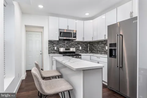 a kitchen with stainless steel appliances a refrigerator stove microwave and cabinets