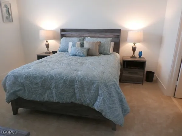 a bed sitting in a bedroom next to a lamp