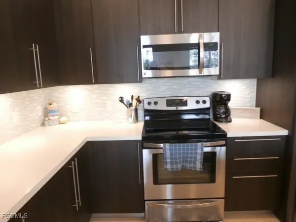 a kitchen with stainless steel appliances a stove a microwave and sink