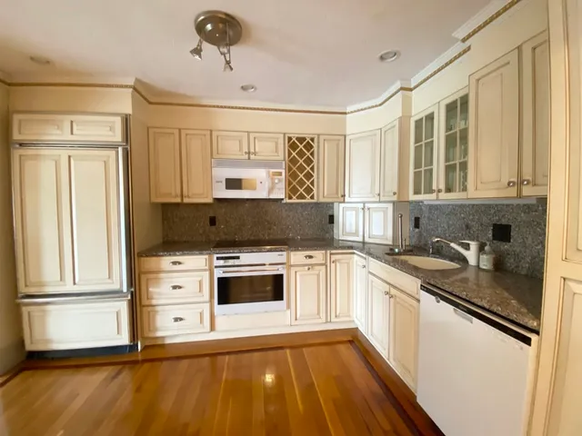 a kitchen with stainless steel appliances granite countertop a stove a sink and a refrigerator