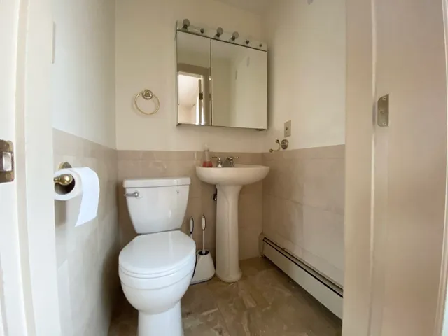 a bathroom with a toilet sink and mirror