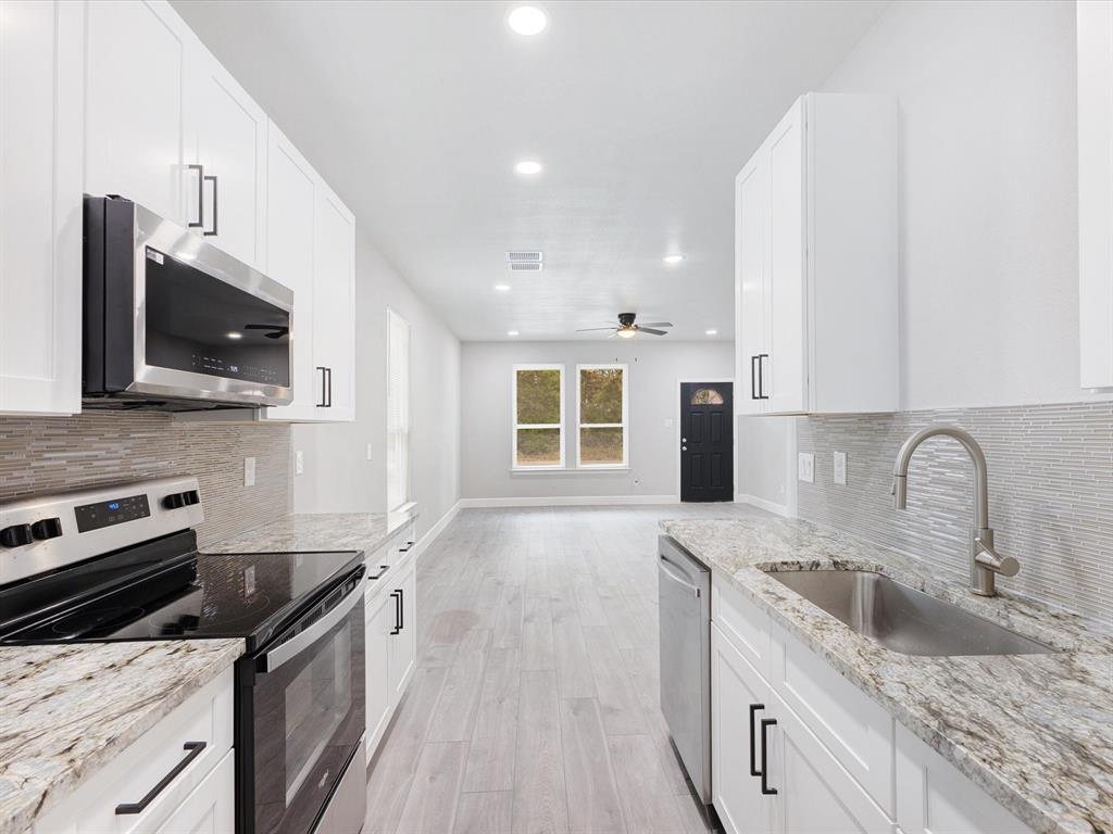 6126 Inca Drive Mabank, TX 75156 - Photo 12 of 31 a kitchen with stainless steel appliances granite countertop a sink stove microwave and refrigerator