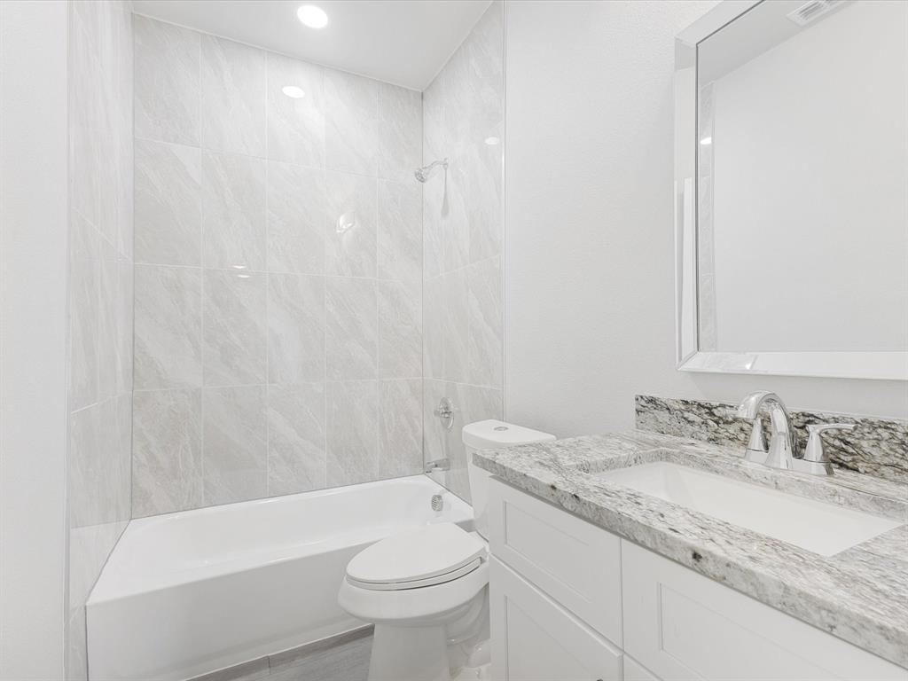 6126 Inca Drive Mabank, TX 75156 - Photo 17 of 31 a bathroom with a granite countertop sink a toilet a mirror and bathtub