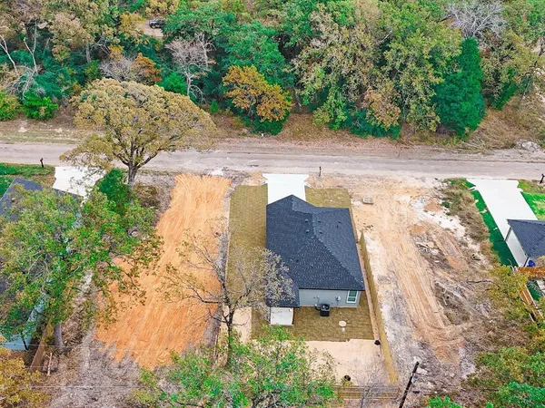 an aerial view of a house with a yard and trees all around