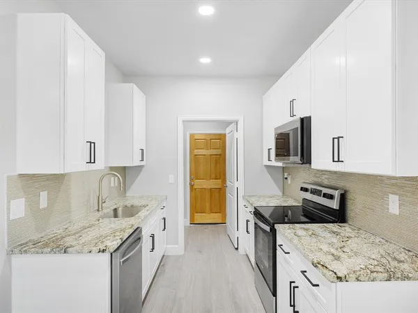 a kitchen with stainless steel appliances granite countertop a sink stove and refrigerator