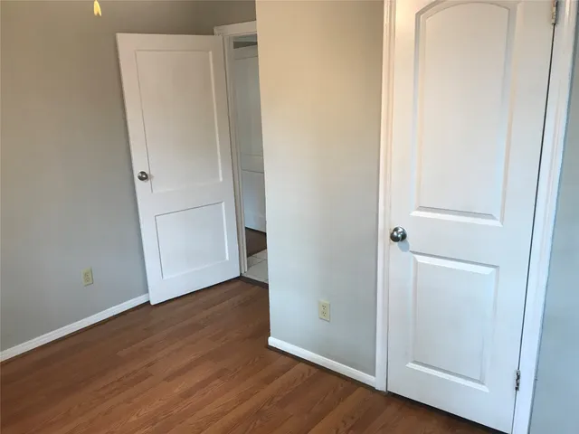 an empty room with wooden floor and closet