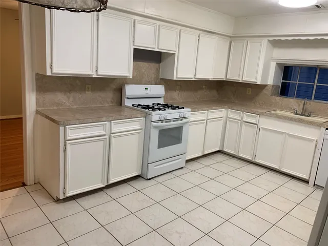 a kitchen with cabinets appliances and a sink