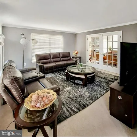 a living room with furniture a flat screen tv and a window