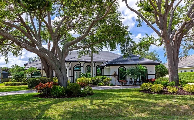 an empty room with a chandelier fan and windows