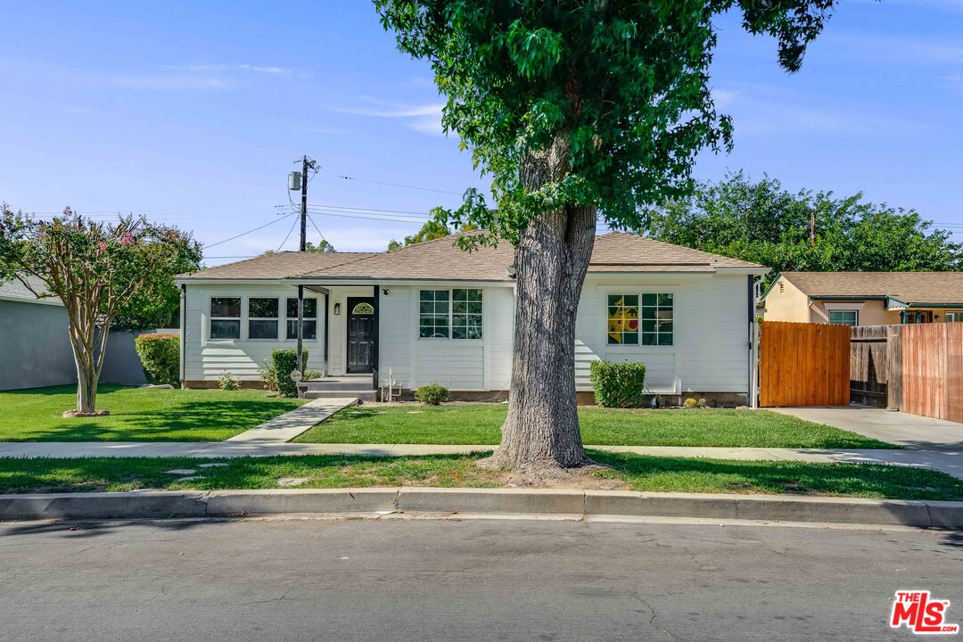 a front view of a house with a yard and trees