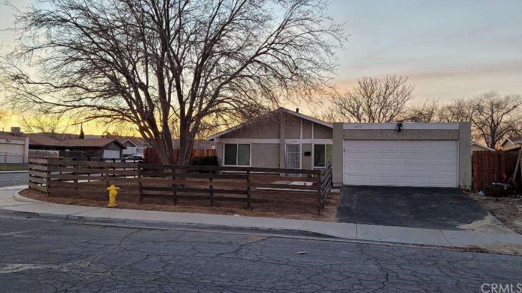 a front view of a house with a tree