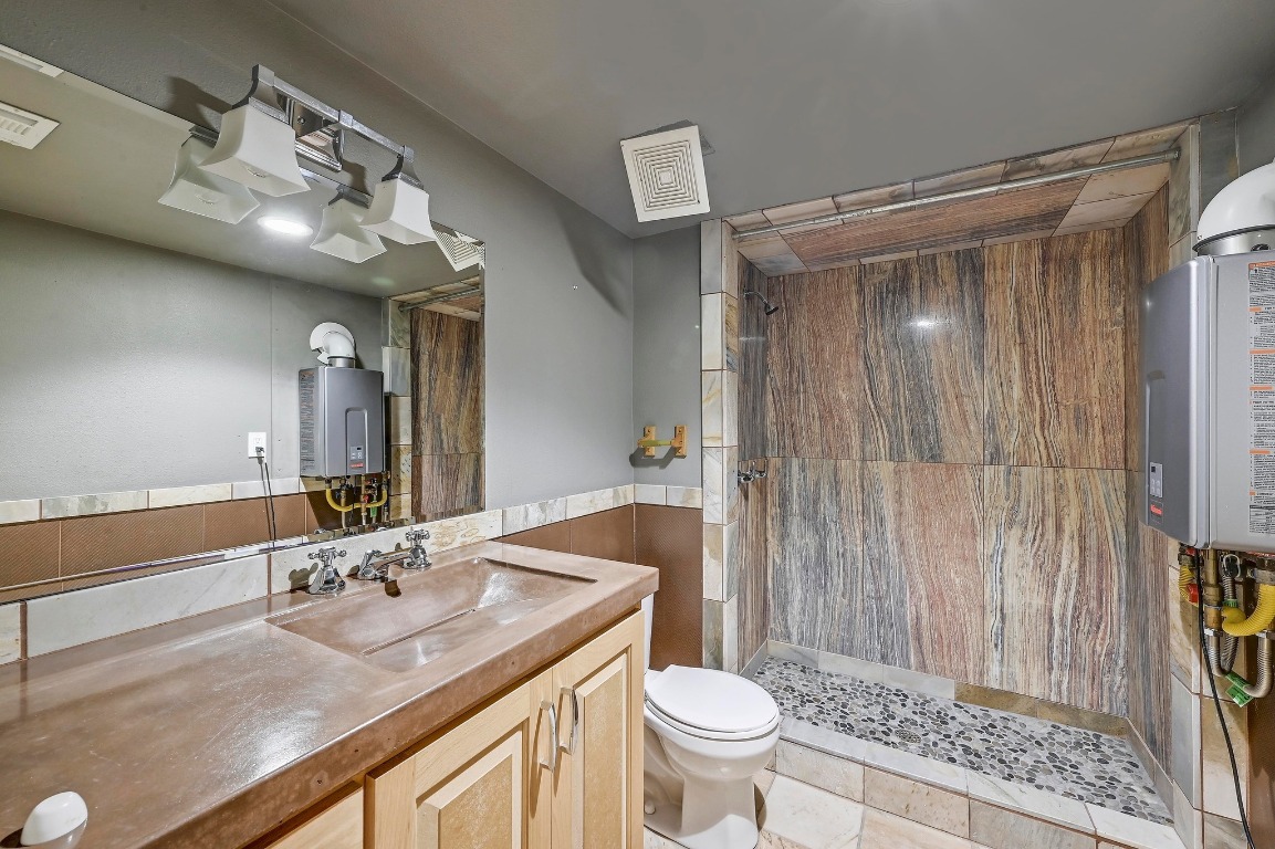 2204 Spring Creek Drive Austin, TX 78704 - Photo 28 of 34 a bathroom with a sink a toilet a mirror and shower