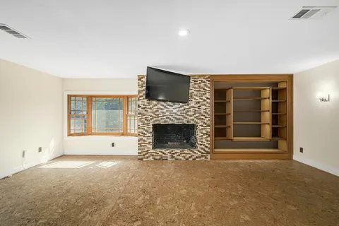 a view of a livingroom with a fireplace and window