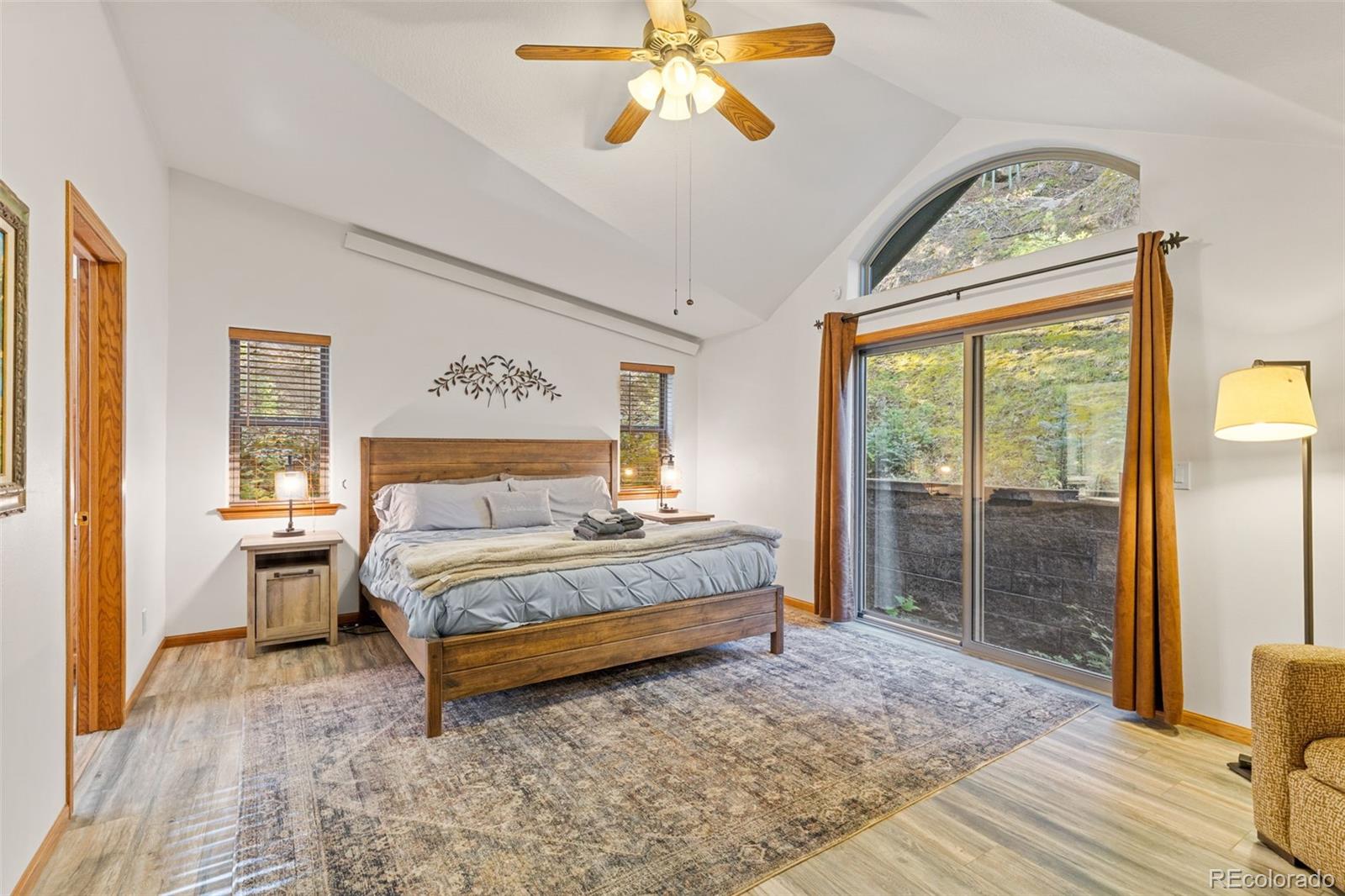 76 Wheel Haven Road Idaho Springs, CO 80452 - Photo 24 of 50 a spacious bedroom with a large bed and a chandelier