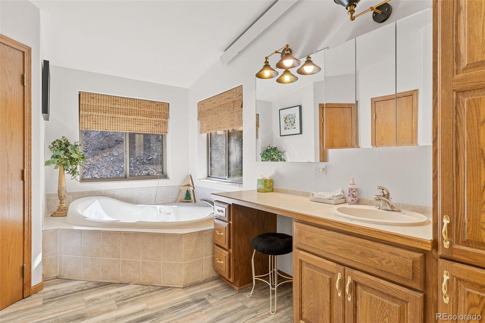 76 Wheel Haven Road Idaho Springs, CO 80452 - Photo 28 of 50 a bathroom with a sink a large mirror and a bathtub