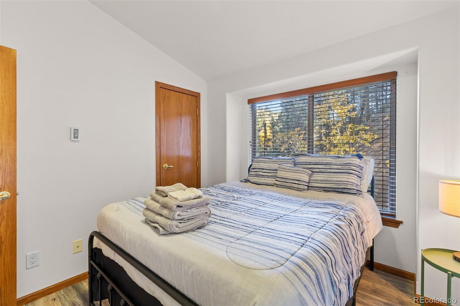 76 Wheel Haven Road Idaho Springs, CO 80452 - Photo 32 of 50 a bedroom with a bed and wooden floor