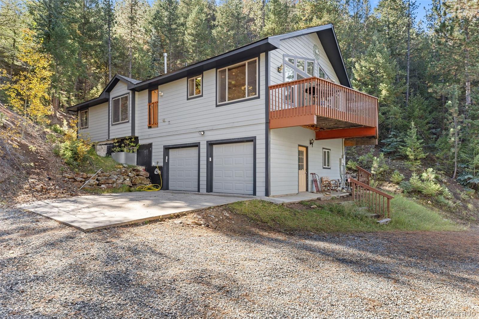 76 Wheel Haven Road Idaho Springs, CO 80452 - Photo 4 of 50 a front view of a house with a yard and garage