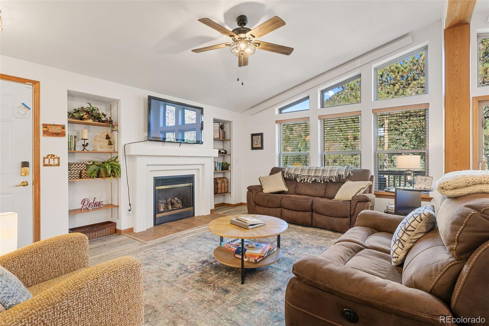 76 Wheel Haven Road Idaho Springs, CO 80452 - Photo 7 of 50 a living room with furniture a fireplace and a large window