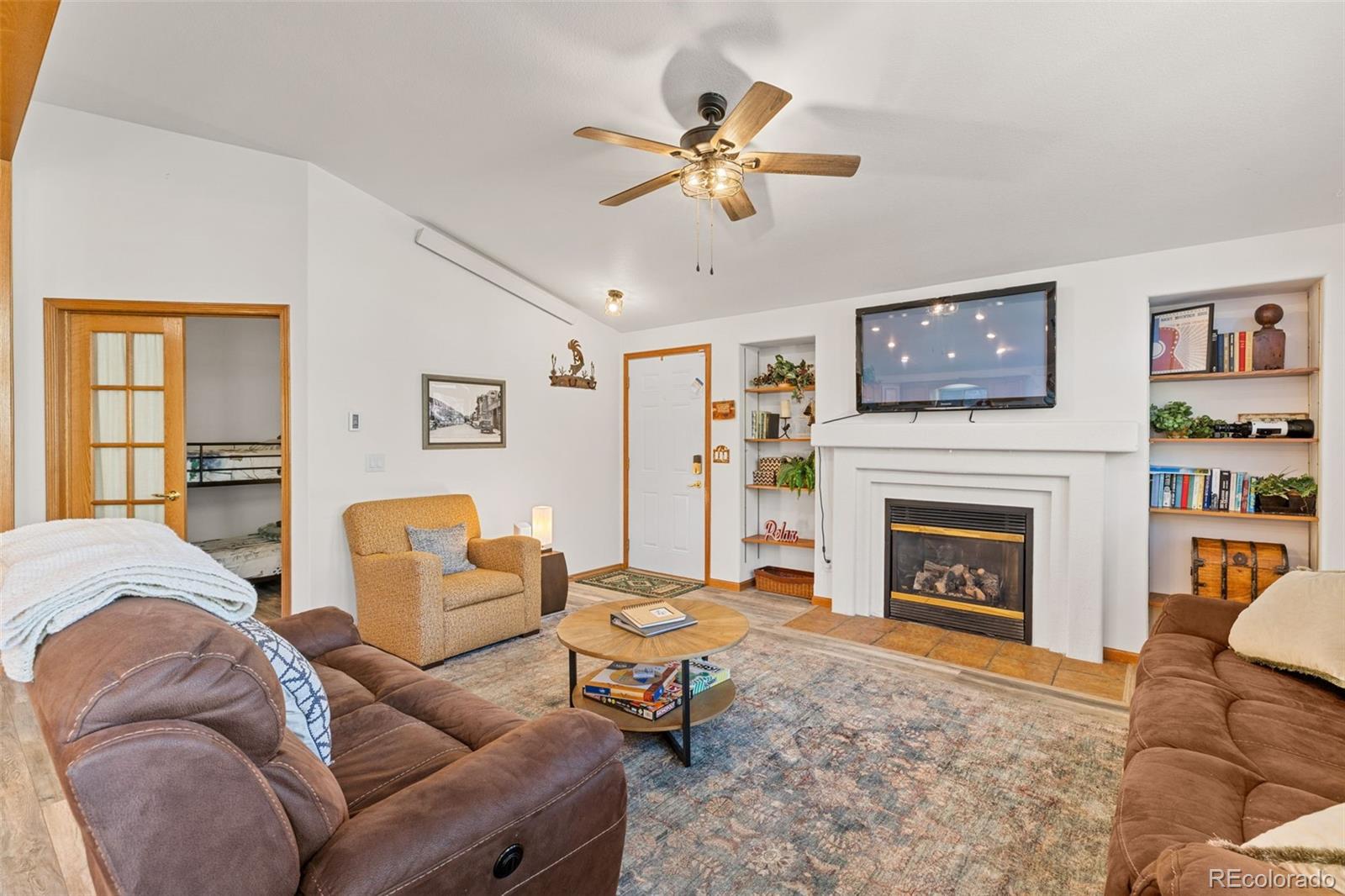 76 Wheel Haven Road Idaho Springs, CO 80452 - Photo 9 of 50 a living room with furniture a flat screen tv and a fireplace