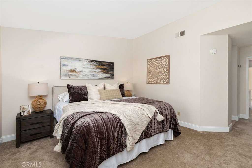 25721 Shell Drive Dana Point, CA 92629 - Photo 22 of 41 a spacious bedroom with a bed and a wall painting
