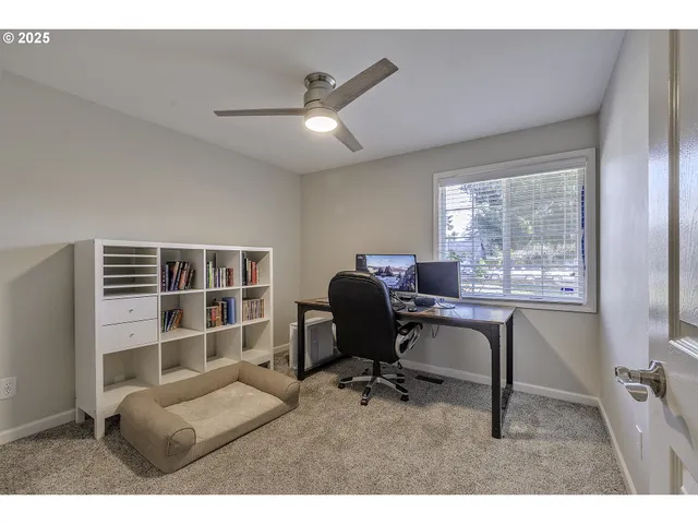 a view of a workspace with furniture and a window