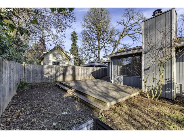a view of a house with backyard and wooden fence