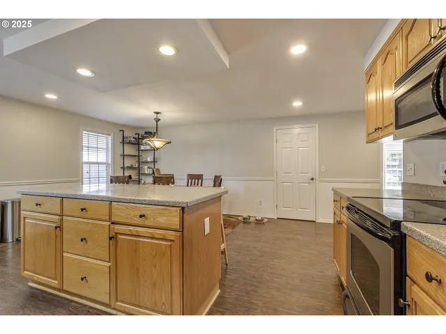 a kitchen with granite countertop a sink stainless steel appliances and cabinets