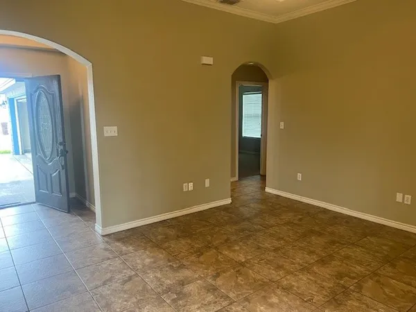 an empty room with a bathroom and mirror