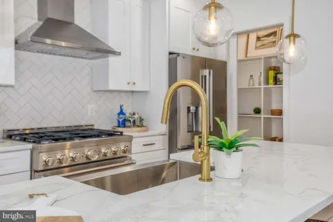 a kitchen with stainless steel appliances granite countertop a stove a sink and a refrigerator