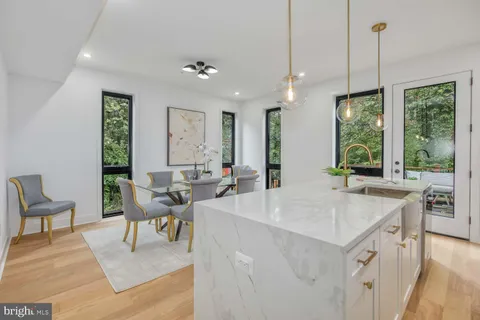 a living room with furniture a large window and dining table