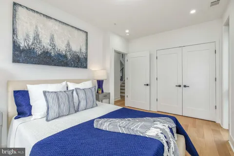 a bedroom with a bed and a painting on the wall