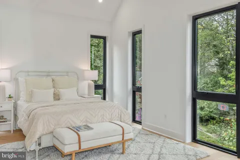 a bedroom with a bed and a large window