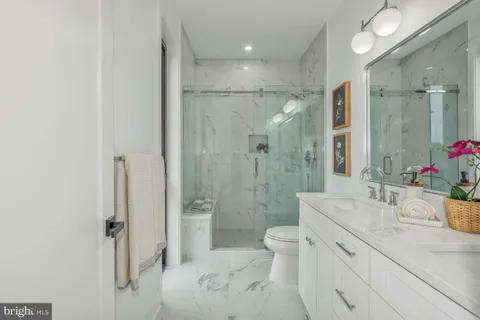 a bathroom with a double vanity sink toilet mirror and shower