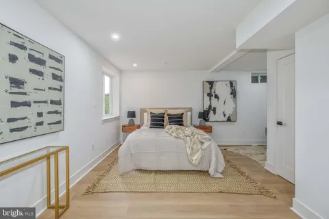 a bedroom with a large bed and painting on the wall