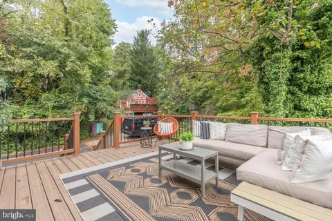 a view of a patio with couches table and chairs with wooden floor and fence