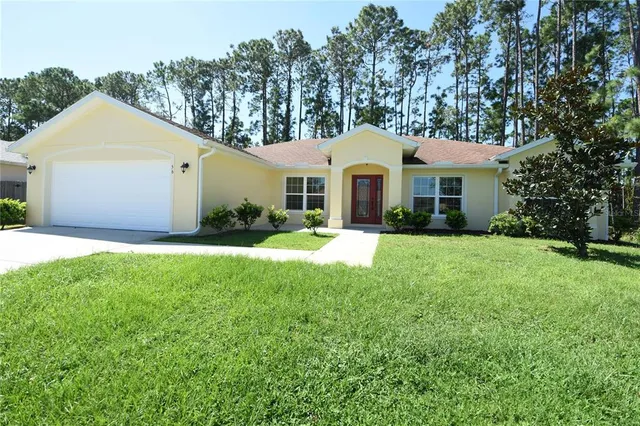 a front view of a house with a garden and trees
