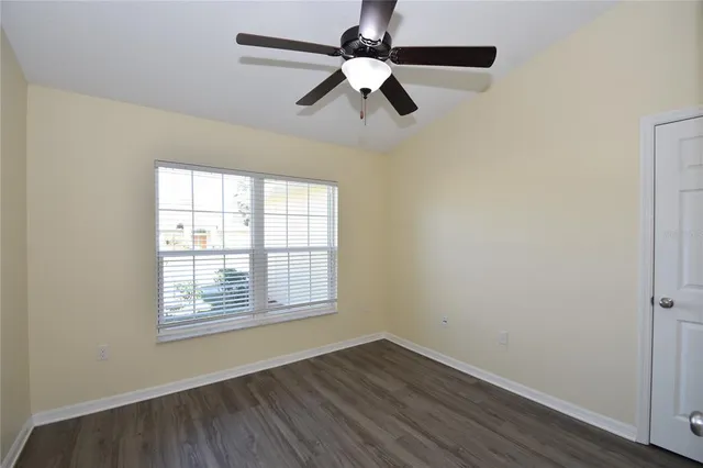 an empty room with a window and a fan