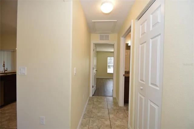 an empty room with wooden floor ceiling fan and windows