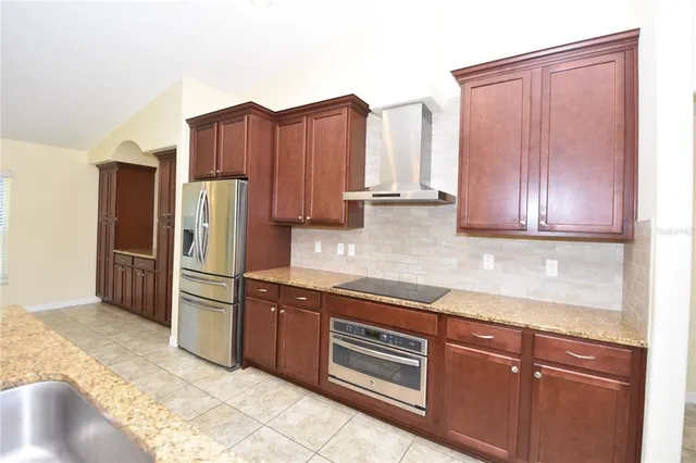 a kitchen with stainless steel appliances granite countertop a refrigerator and a sink