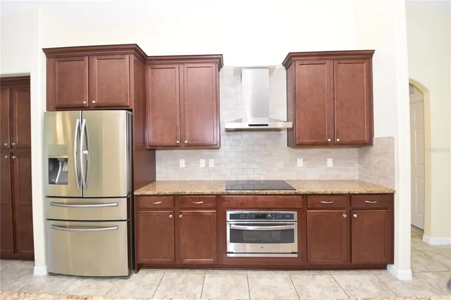 a kitchen with stainless steel appliances granite countertop a refrigerator and a stove top oven