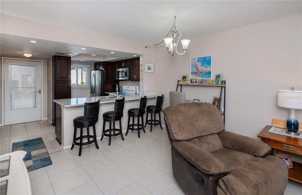 25275 Rampart Boulevard, Unit 1802 Punta Gorda, FL 33983 - Photo 22 of 41 a living room with furniture a dining table and a chandelier