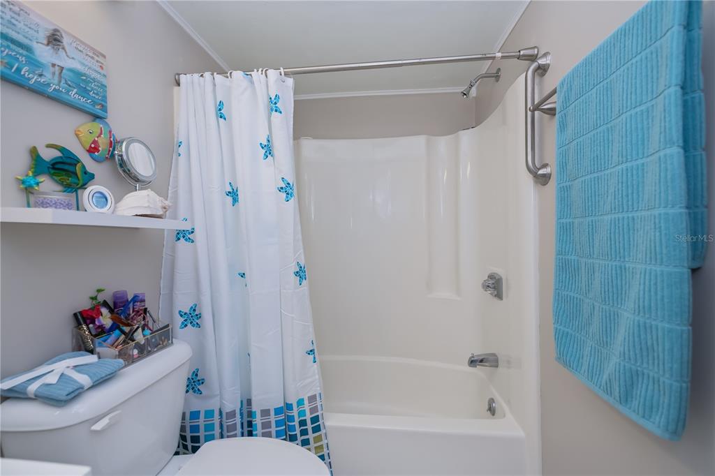 25275 Rampart Boulevard, Unit 1802 Punta Gorda, FL 33983 - Photo 29 of 41 a bathroom with a shower a toilet and a shower curtain