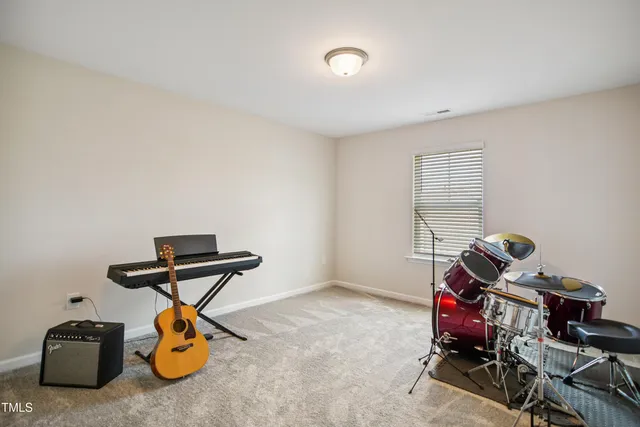a room with gym equipment and wooden floor