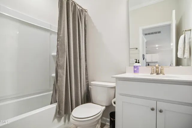 a bathroom with a sink a toilet a mirror and shower