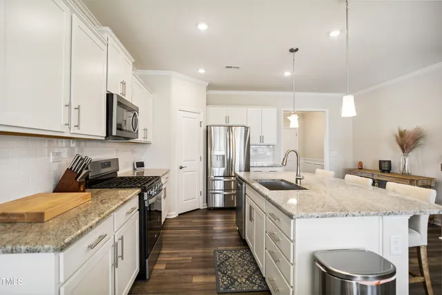a kitchen with stainless steel appliances granite countertop a sink stove and refrigerator