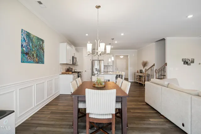 a view of a dining room with furniture a chandelier and wooden floor