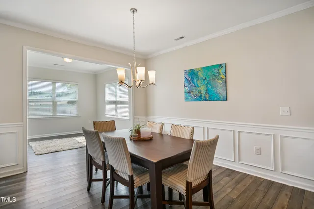 a view of a dining room with furniture wooden floor and chandelier