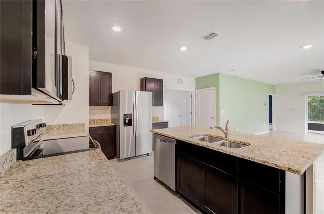 a kitchen with a sink refrigerator and microwave